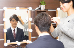 女性ヘアメイクにヘアメイクをされている就活男子写真