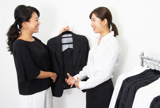 女性のヘアメイクが女子就活生にレンタルスーツを選ぶ写真