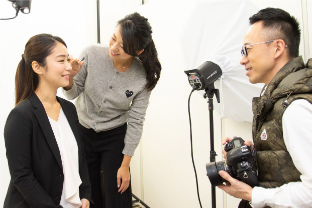 女性のヘアメイクとカメラマンが女子就活生を撮影する写真
