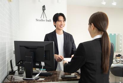 証明写真と撮影データを渡される男子就活生